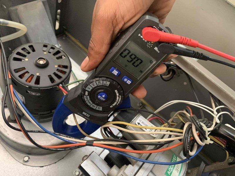 Performed comprehensive heating tune-up on a 10+ year old system located in utility closet. Conducted electrical diagnostics using multimeter to test blower motor assembly and capacitor, recording voltage readings of 75.4V to verify proper system operation. Inspected all electrical connections, wire bundles, and components within the unit to ensure safe and efficient heating system performance for the upcoming season.