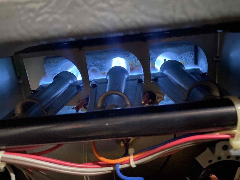 Completed comprehensive heating tune-up on ground-level furnace unit. Performed full system diagnostics including electrical testing with multimeter showing 0.27 amp draw, inspected burner assembly operation with all three burners igniting properly and producing clean blue flames, verified gas manifold pressure and connections, examined heat exchanger for cracks or deterioration, tested safety controls and limit switches, checked all electrical connections and wiring, and confirmed proper combustion and venting. System operating within manufacturer specifications with no immediate repairs required.