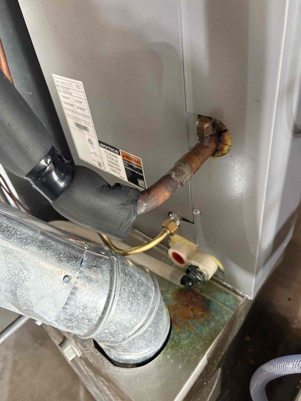 Performed secondary assessment of HVAC system and water heater installation as requested. Documented extensive corrosion on copper water supply lines entering water heater unit, showing significant oxidation with blue-green patina and rust discoloration. Inspected refrigerant line connections at air handler cabinet, noting degraded foam insulation on suction line and service valve accessibility. Photographed corroded plumbing connections and HVAC component conditions for reference and further evaluation recommendations.