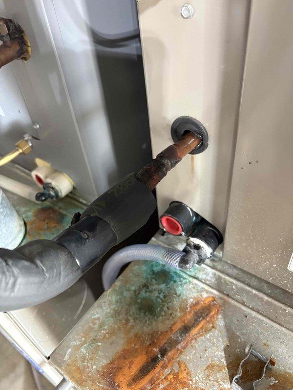 Performed secondary assessment of HVAC system and water heater installation as requested. Documented extensive corrosion on copper water supply lines entering water heater unit, showing significant oxidation with blue-green patina and rust discoloration. Inspected refrigerant line connections at air handler cabinet, noting degraded foam insulation on suction line and service valve accessibility. Photographed corroded plumbing connections and HVAC component conditions for reference and further evaluation recommendations.