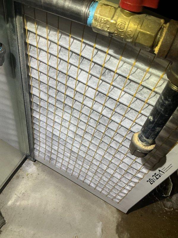 Responded to urgent service call for GF interlock system error code with blinking red indicator on recently installed HVAC unit less than one year old. Upon inspection, discovered severe condensation buildup throughout the system and surrounding ductwork in the mechanical area, indicating a critical indoor air quality issue. The excessive moisture accumulation on metallic surfaces and equipment suggested improper humidity control, inadequate ventilation, or potential drain line malfunction affecting the evaporator coil assembly. Inspected the 2025 model evaporator coil unit with heat exchanger grid, refrigerant line connections with brass valve fittings, and associated plumbing components. Documented extensive water droplet formation on ductwork and system components, which likely triggered the ground fault interlock safety mechanism due to moisture intrusion near electrical components. Photographed the coil face assembly and condensation conditions for warranty documentation purposes.