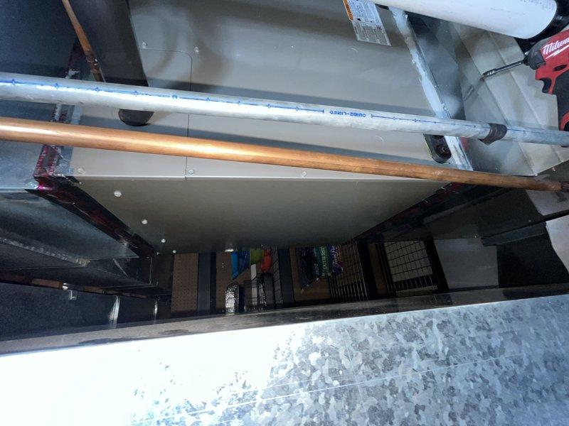 Completed comprehensive tune-up maintenance on single residential HVAC system including outdoor condensing unit and indoor furnace located in basement. Performed standard preventative maintenance procedures on black horizontal-discharge condenser unit positioned on concrete pad adjacent to building exterior, inspecting refrigerant levels, electrical connections, and fan motor operation. Accessed furnace system through attic space to inspect heat exchanger, burner assembly, and venting components, verifying proper combustion and airflow through ductwork and PVC flue piping.