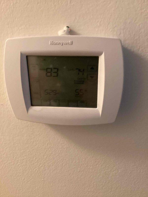 Responded to no cooling complaint on 10+ year old outdoor unit located on side of home. Upon arrival, found system had been shut off with only fan running. Accessed electrical compartment and inspected internal components including capacitor and wiring connections. Thermostat displayed 83 degrees, confirming lack of cooling performance. Documented unit condition with exterior debris present around base and evaluated system for necessary repairs to restore cooling operation.