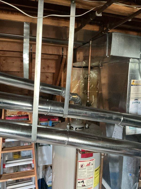 Completed installation of a 50-gallon gas tall water heater in utility space with platform stairs access. Two-technician team removed existing White Rodgers unit and installed new heater with 3/4" pressure reducing valve. Protected carpeted stairway during equipment transport and positioned unit in mechanical room alongside existing HVAC ductwork and plumbing systems. Installation completed per manufacturer specifications and local code requirements without requiring plumbing permit sticker per St. Charles County regulations.