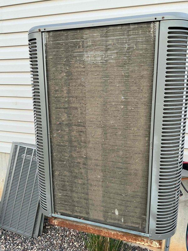Completed comprehensive tune-up service on a 9-year-old residential air conditioning system located in a raised basement installation. Upon arrival, condenser coil exhibited heavy accumulation of dirt, dust, and environmental debris throughout the fin surfaces, significantly restricting airflow and reducing heat transfer efficiency. Performed thorough coil cleaning to restore proper airflow, inspected all electrical connections, verified refrigerant pressures, tested capacitor performance, and confirmed proper system operation. Unit returned to optimal operating condition with improved efficiency and airflow.