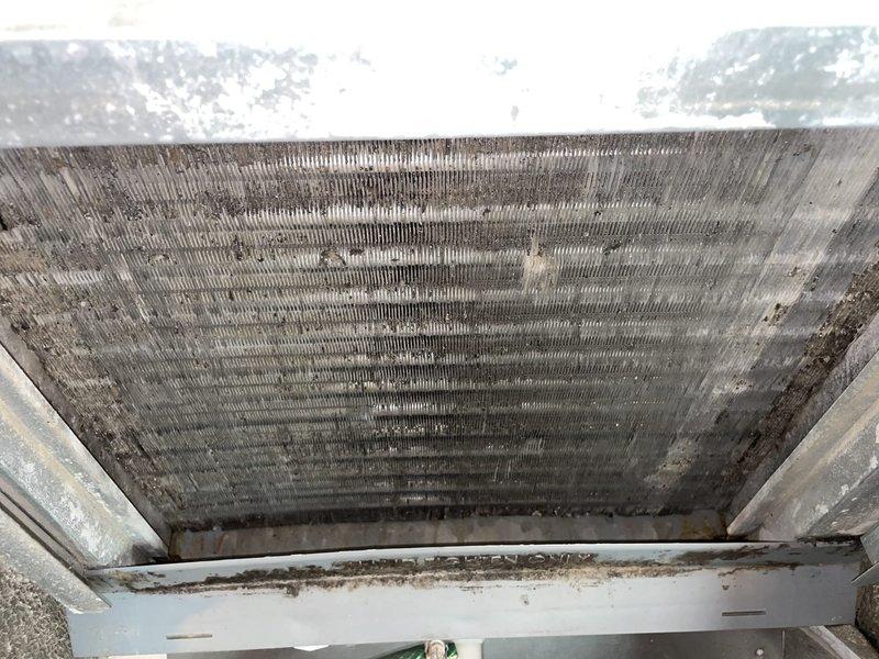 Responded to service call for water leaking near filter cabinet on 16-year-old air conditioning system. Upon inspection, found evaporator coil and filter heavily contaminated with dust and debris accumulation, causing restricted airflow and condensate drainage issues. Documented conditions with photos showing significant buildup on coil fins and completely saturated air filter blocking proper system operation, which was the source of the water leakage.