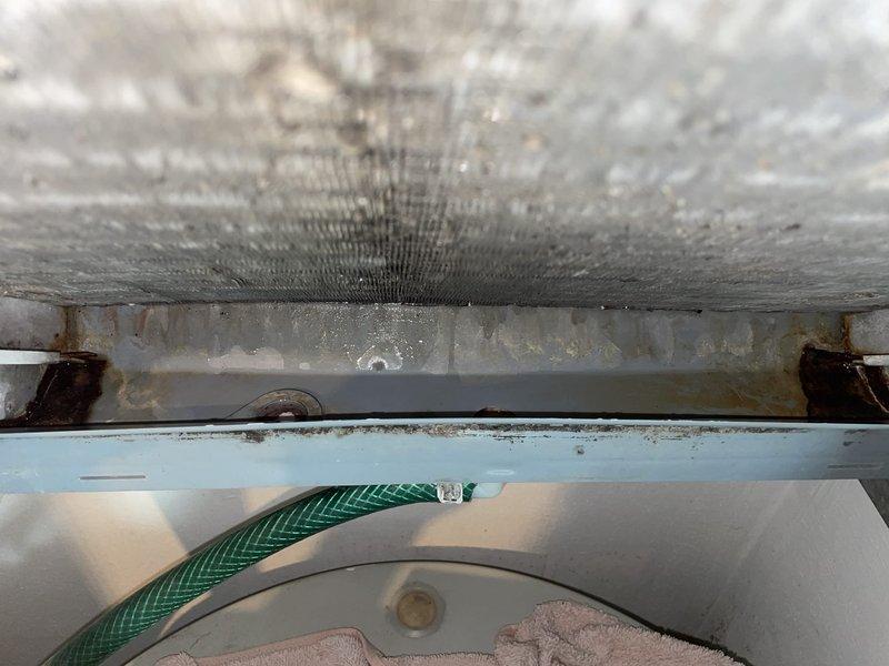 Responded to service call for water leaking near filter cabinet on 16-year-old air conditioning system. Upon inspection, found evaporator coil and filter heavily contaminated with dust and debris accumulation, causing restricted airflow and condensate drainage issues. Documented conditions with photos showing significant buildup on coil fins and completely saturated air filter blocking proper system operation, which was the source of the water leakage.