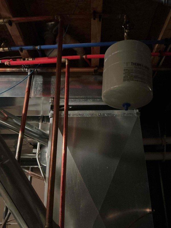 Responded to service call for insufficient hot water production in basement-located water heater. Upon inspection, determined existing unit was beyond economical repair. Removed and properly disposed of old water heater per local regulations. Installed new 50-gallon tall gas water heater with appropriate venting, gas line connections, and water supply lines. Connected hot and cold water distribution lines using PEX piping with proper support brackets. Installed expansion tank and pressure relief valve per code requirements. Completed all copper pipe connections and verified proper gas line installation. Applied for and obtained plumbing permit 26PLU-18721 with corresponding inspection sticker affixed to installation. Tested unit for proper ignition, combustion, and temperature output. Verified all connections for leaks and ensured adequate clearances around unit. System is now operational and producing hot water at appropriate temperatures.