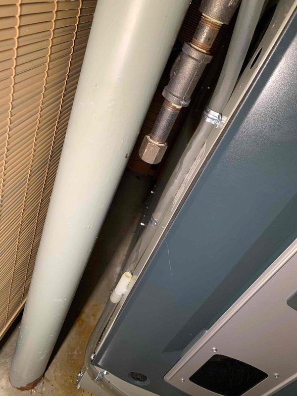 Responded to callback for A/C condensate drain overflow issue on 2-year-old Trane system. Upon arrival, found water pooling under furnace and in drain pan due to condensate line blockage that developed following recent service visit. Cleared obstruction from condensate drain tubing, verified proper drainage flow, and tested system operation to ensure condensate was routing correctly through drain line without overflow. Inspected furnace cabinet and components for water intrusion, confirming no damage to internal parts. Cleaned excess water from drain pan and surrounding area. System restored to normal operation with condensate draining properly.
