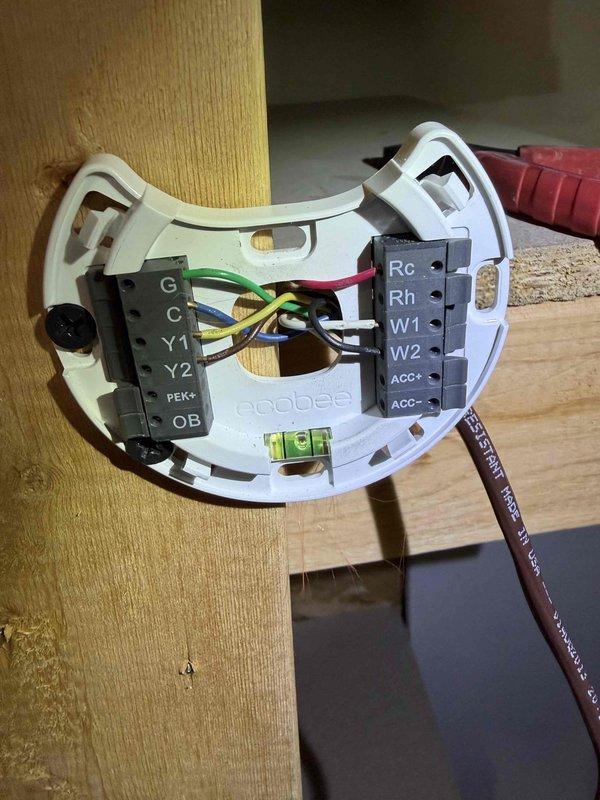 Responded to no cooling complaint with thermostat reading 80°F. Upon arrival, inspected ecobee3 thermostat wiring and verified proper terminal connections at R, C, Y, G, and W terminals. Examined condensate drain pan at air handler, found clear drainage channel with minor debris accumulation but no blockage affecting system operation. Confirmed all low voltage wiring secure and thermostat properly leveled and mounted. System operational upon departure with normal cooling cycle restored.