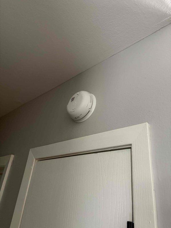 Performed comprehensive electrical safety inspection of residential property. Conducted thermal imaging scan of all accessible outlets and wall surfaces to identify potential hotspots or abnormal heat signatures—no elevated temperatures detected. Inspected main electrical panel and documented existing conditions: noted moderate corrosion and rust on panel frame edges where metal meets wall surface, indicating possible moisture exposure over time. Verified all circuit breakers for proper seating and operation; all breakers functional with no signs of overheating or damage. Evaluated wire management within panel box—connections secure though wire bundling shows typical age-related congestion. Tested smoke detector for proper operation and battery condition. Inspected visible outlets throughout property for secure mounting, proper grounding, and signs of arcing or heat damage—all outlets tested within normal parameters. Overall electrical system operating safely with no immediate hazards 