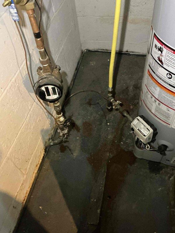 Performed comprehensive HVAC system inspection and provided estimate for multiple safety and efficiency corrections on basement-installed unit. Identified need for flexible liner connection installation, verification and tightening of all screws and unions throughout the system, proper bonding wire installation for gas piping to water heater per code requirements, sealing of evaporator cabinet opening to prevent air infiltration, insulation of refrigerant lines, and relocation of union connector for improved accessibility and code compliance. Documented existing conditions with photographs showing gas valve assembly, electrical connections, copper gas piping, and water heater installation with visible floor moisture concerns.