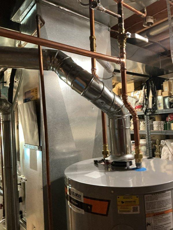 Installed a 50-gallon gas tall water heater with proper copper supply line connections, brass fittings, and metallic vent flue system in accordance with code requirements. Installation included integration with existing expansion tank and pressure regulation components, with permit obtained through City of Ballwin (Permit #26-004631). All connections were secured, tested for proper operation, and system was verified functional upon completion.