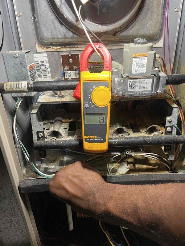 Completed comprehensive tune-up on 10-year-old furnace located in basement. Performed diagnostic testing using clamp meter to verify electrical draw on blower motor, recording 13-amp reading within normal operating parameters. Inspected gas valve assembly, burner assembly, and all electrical connections including Honeywell flame sensor and control wiring. All components found to be functioning properly with no immediate safety concerns, though unit's age was noted for future consideration.