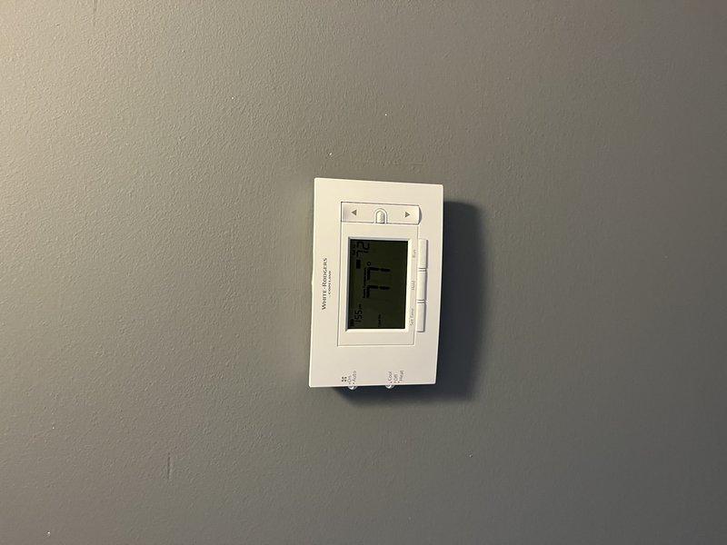Replaced two existing thermostats with new White-Rodgers programmable units on both HVAC systems. Installed clean white thermostats, verified proper wiring connections, configured temperature settings, and confirmed both units were operating correctly with systems responding to temperature calls.