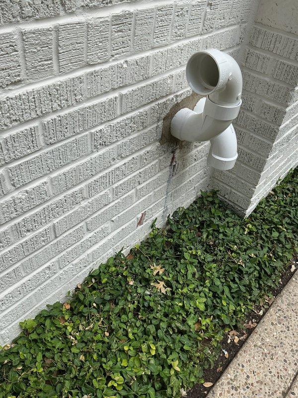 Returned to property to address PVC termination penetration through exterior wall. Removed deteriorated mortar around dual PVC pipe elbows and resealed penetrations with fresh mortar to ensure proper weatherproofing and structural integrity. Unit confirmed operational upon completion.