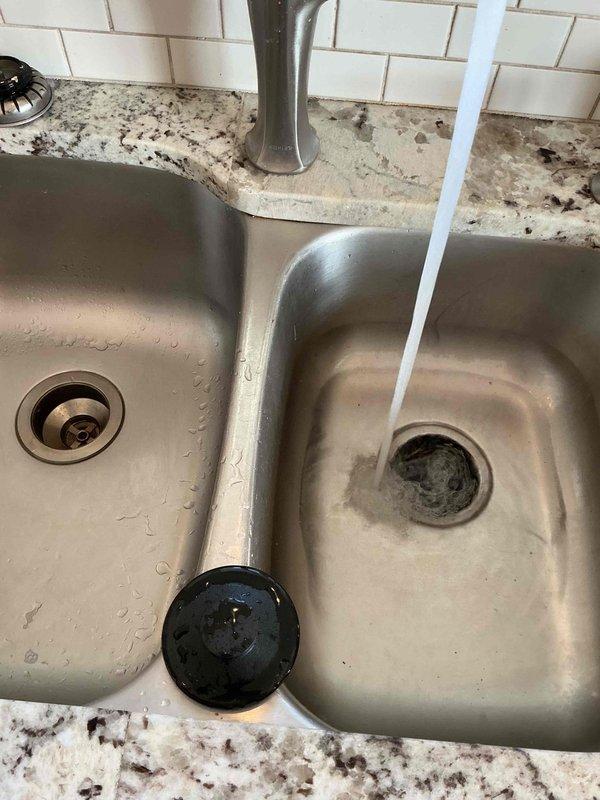Responded to clogged drain service call at kitchen double-basin sink. Upon arrival, assessed the stainless steel sink installed in granite countertop and confirmed drainage issue in the system. Utilized drain snake equipment to clear the blockage from the affected drain line. Successfully restored proper water flow and drainage function to both basins. Tested the system by running water through the faucet to verify complete clearance and proper drainage performance. Left the work area clean with all fixtures operating normally.