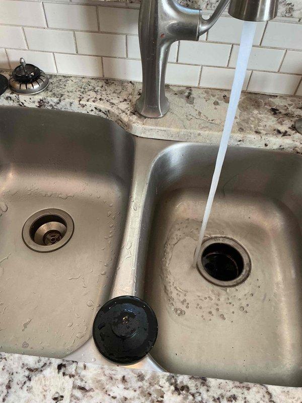 Responded to clogged drain service call at kitchen double-basin sink. Upon arrival, assessed the stainless steel sink installed in granite countertop and confirmed drainage issue in the system. Utilized drain snake equipment to clear the blockage from the affected drain line. Successfully restored proper water flow and drainage function to both basins. Tested the system by running water through the faucet to verify complete clearance and proper drainage performance. Left the work area clean with all fixtures operating normally.