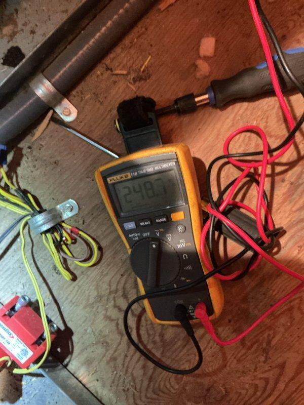 Responded to no-cool complaint on 13-year-old upstairs air conditioning system located in second-floor knee attic with horizontal furnace configuration. Accessed unit via pull-down attic stairs and navigated tight workspace with equipment positioned on plywood platform above ceiling drywall. Upon arrival, performed visual inspection of system components and electrical connections, noting age-related wear and dust accumulation on various parts. Utilized Fluke 116 HVAC multimeter to perform diagnostic voltage testing at control board and transformer connections, confirming 24-volt reading at low-voltage circuit. Inspected blower motor assembly and ECM motor operation, examining electrical terminations and wiring harness connections including ground conductors. Evaluated heating element connections and mounting brackets, observing normal operational wear patterns and mineral deposits consistent with system age. Documented existing conditions through photography for service records. Comple
