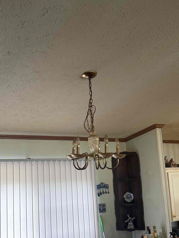 Completed installation of three ceiling fans in residential property. First unit installed features bronze finish with integrated cage-style light fixture and five-blade configuration, mounted in bedroom with textured ceiling. Second unit consists of traditional chandelier-style fixture with multiple candle bulbs, chain-mounted in kitchen/dining area with crown molding. Verified proper electrical connections, tested fan operations at all speed settings, and confirmed lighting functionality on both fixtures. All installations secured to ceiling joists per manufacturer specifications and local electrical code requirements.
