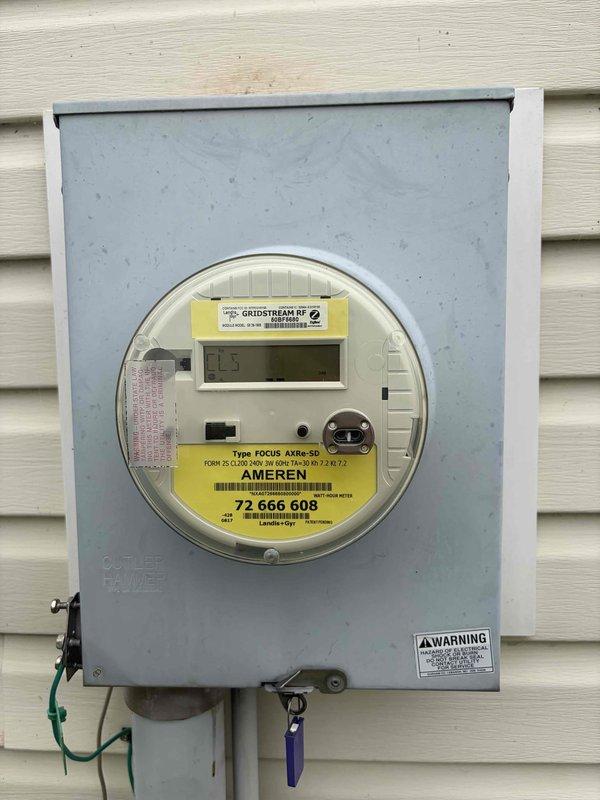 Responded to service call for circuit breaker that would not remain in the on position for two-bedroom circuit. Upon arrival, conducted visual inspection of exterior electrical service equipment including meter enclosure and main panel accessibility. Verified power supply integrity at meter base and confirmed proper utility connection. Documented existing electrical infrastructure with digital photographs showing Ameren Gridstream RF digital meter installation, service entrance equipment, and exterior panel configuration mounted on residential vinyl siding. Based on symptom description of breaker failing to lock in position, issue indicates internal breaker mechanism failure requiring breaker replacement to restore reliable power to affected bedroom circuits.