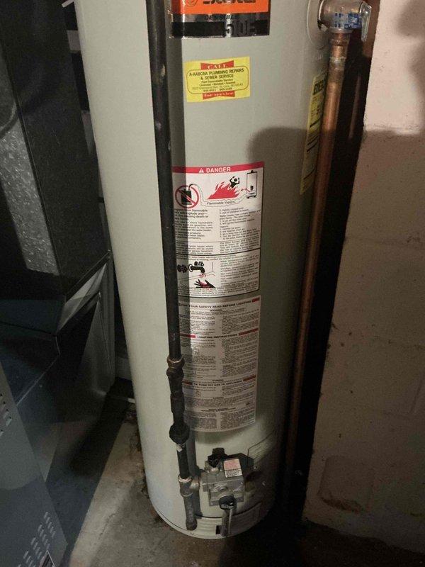 Replaced existing 6-year-old water heater with new 40-gallon gas short State brand tanked water heater in basement utility area. Installation included connecting copper supply lines, installing 3/4-inch ball valve, and routing black gas piping to unit. All plumbing connections were secured with proper fittings and tested for leaks. Verified proper venting configuration and clearances from surrounding equipment including adjacent water softener. Confirmed all safety labels and warning decals were visible and intact on new unit. System was pressurized, filled, and tested for proper operation with no leaks detected at any connection points.