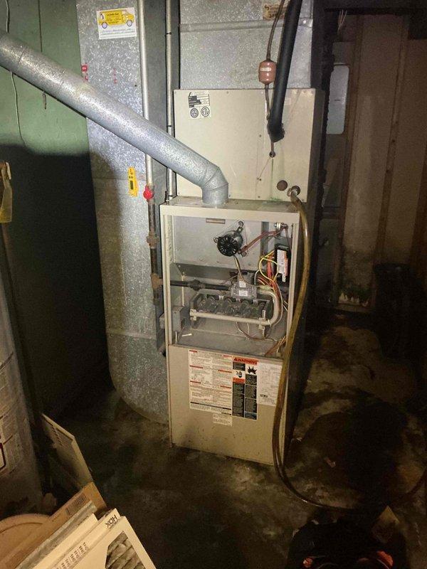 Completed comprehensive Supertune maintenance service on two HVAC units: one furnace located in basement and one AC unit positioned on side of home, both approximately 10 years old. Performed full system inspection, cleaning, and testing on both units including blower motor assembly examination, electrical connection verification, and filter assessment. Documented existing condition with photos showing normal wear consistent with unit age and minor surface discoloration on exterior housing of one unit.