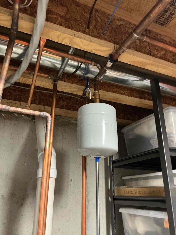 Successfully installed a 50-gallon power vent Bradford White water heater in basement utility area with proper copper piping connections and expansion tank integration. Completed installation under permit 26PLU-19111 with permit ID sticker affixed to unit, documented expansion tank pressure settings as required, and utilized extension ladder to accommodate 10-foot ceiling height for overhead plumbing connections. All work performed to code with grade-level access, resulting in fully operational water heating system with proper venting and safety compliance.