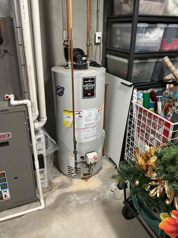 Successfully installed a 50-gallon power vent Bradford White water heater in basement utility area with proper copper piping connections and expansion tank integration. Completed installation under permit 26PLU-19111 with permit ID sticker affixed to unit, documented expansion tank pressure settings as required, and utilized extension ladder to accommodate 10-foot ceiling height for overhead plumbing connections. All work performed to code with grade-level access, resulting in fully operational water heating system with proper venting and safety compliance.