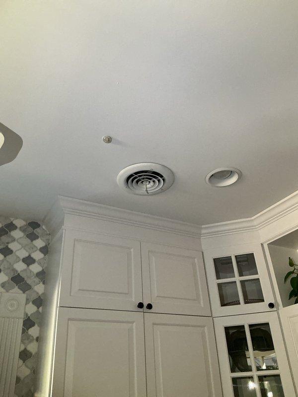 Responded to water leak complaint on 2-year-old Lennox system with uninsulated ductwork installed 3-4 years ago. Inspected attic ductwork and identified condensation issues on metal supply ducts running from attic to both floors of residence. Previous repair had been completed on one section of ductwork; however, discovered additional uninsulated duct section experiencing similar condensation problems resulting in water damage and mold growth in affected areas. Documented conditions with photographs showing uninsulated cylindrical metal duct in attic space and interior ceiling damage in kitchen area. Assessed extent of water damage and mold contamination requiring remediation. Recommended complete insulation of all exposed ductwork in unconditioned attic space to prevent future condensation during cooling season and additional water intrusion damage to structure.