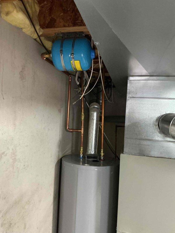 Responded to active water leak from failed water heater of unknown age causing property damage. Removed and replaced existing unit with new 50-gallon gas tall water heater. Installation included connecting copper supply lines, gas line, and proper venting per manufacturer specifications. Verified all connections for leaks, tested temperature and pressure relief valve operation, and confirmed proper ignition and burner function. System pressurized and operational upon completion with no leaks detected.