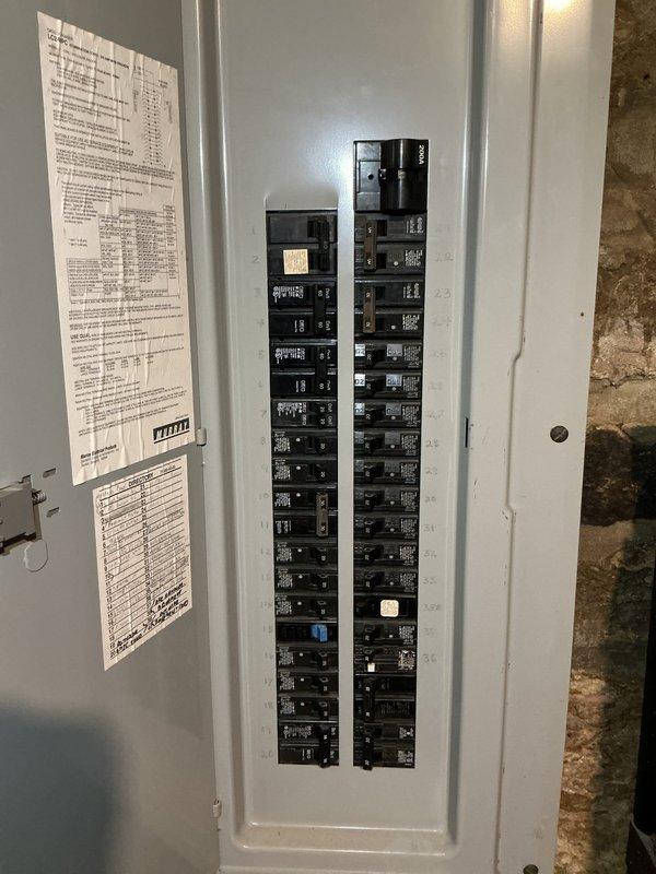 Responded to service call for non-functioning stairwell light fixture with suspected wire damage from recent AC installation. Upon arrival, accessed electrical panel to inspect circuit breakers and verify power distribution to affected fixture circuit. Photographed panel configuration showing dual columns of circuit breakers with directory labels for documentation purposes. Traced circuit serving stairwell lighting and confirmed panel integrity with all breakers properly seated and functional. Investigation revealed wiring issue consistent with customer's concern regarding recent HVAC work potentially compromising electrical connections. Restored power to stairwell fixture and verified proper operation upon completion.
