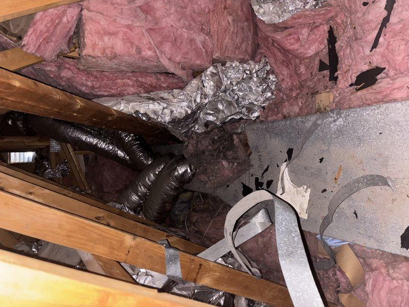 Responded to service call for condensation issues on attic ductwork causing water damage and mold growth on interior ceiling. Inspected HVAC system including 8-year-old Lennox unit and attic ductwork installation. Found inadequate insulation on flexible ductwork allowing warm, humid attic air to contact cold supply ducts, resulting in excessive condensation formation. Condensation was dripping through ceiling penetrations at supply register, creating visible water stains, ceiling texture damage, and mold development. Assessed ductwork insulation levels and vapor barrier integrity throughout accessible attic areas. Documented existing damage to ceiling around supply vent showing cracking and deterioration from prolonged moisture exposure. Recommended proper duct insulation upgrade with vapor barrier to eliminate condensation, professional mold remediation for affected ceiling areas, and ceiling repair to restore structural integrity and appearance.