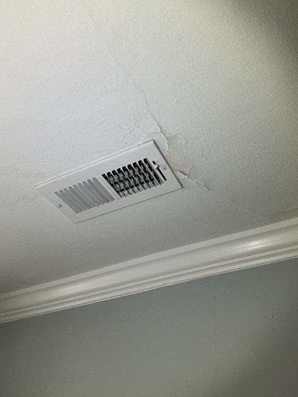 Responded to service call for condensation issues on attic ductwork causing water damage and mold growth on interior ceiling. Inspected HVAC system including 8-year-old Lennox unit and attic ductwork installation. Found inadequate insulation on flexible ductwork allowing warm, humid attic air to contact cold supply ducts, resulting in excessive condensation formation. Condensation was dripping through ceiling penetrations at supply register, creating visible water stains, ceiling texture damage, and mold development. Assessed ductwork insulation levels and vapor barrier integrity throughout accessible attic areas. Documented existing damage to ceiling around supply vent showing cracking and deterioration from prolonged moisture exposure. Recommended proper duct insulation upgrade with vapor barrier to eliminate condensation, professional mold remediation for affected ceiling areas, and ceiling repair to restore structural integrity and appearance.