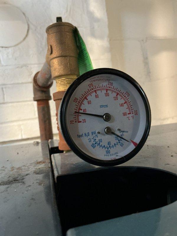 Completed scheduled boiler tune-up and safety inspection. Verified proper operation of pressure and temperature gauges, confirming readings within normal parameters. Inspected pressure relief valve, copper piping connections, and all brass fittings for signs of leaks or corrosion. Noted evidence of moisture on concrete floor near expansion tank, documented conditions with photos for customer awareness. All components functioning properly at time of service completion.