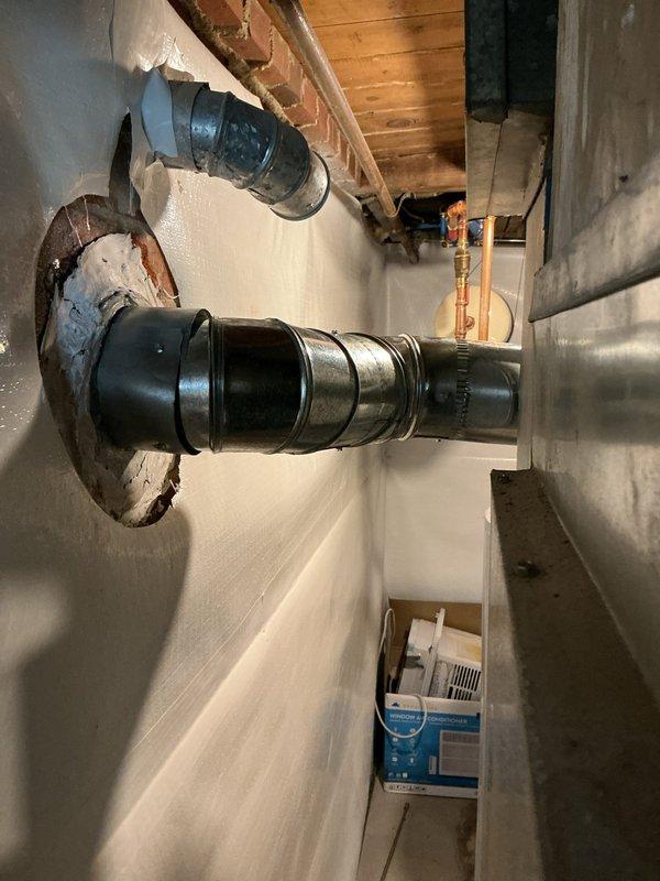Responded to service call regarding improper flue pipe penetration through wall requiring clearance correction. Upon inspection, identified metal flue pipe penetrating through wall surface with inadequate clearance and significant rust staining indicating long-term corrosion and moisture exposure. Flue pipe lacked proper thimble installation to maintain required clearance from combustible materials per code requirements. Documented existing conditions showing corroded pipe threading, deteriorated wall penetration, and improper installation that poses potential safety hazard. Provided quote for installation of raised thimble assembly to establish proper clearance between flue pipe and surrounding combustible wall materials, ensuring code-compliant installation for real estate transaction requirements.