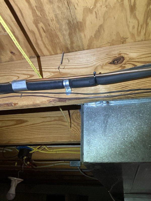 Responded to service call for 9-year-old air conditioning unit experiencing loud booming noise upon startup. Performed diagnostic inspection of basement-mounted system and associated ductwork infrastructure. Inspected refrigerant lines, electrical connections, and mounting hardware in crawl space area to identify source of abnormal sound. Documented existing conditions of copper line sets, electrical junction boxes, and structural mounting points with photographic evidence for service records.