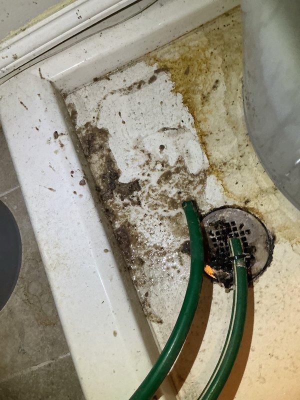 Responded to no cooling call on 7-year-old ground-level unit located in utility closet. Upon arrival, found AC system not turning on as reported. Inspection revealed clogged condensate drain line causing float switch activation and preventing system operation. Cleared drain line obstruction, flushed drainage system, and verified proper flow. Observed significant contamination and mold growth in drain pan requiring cleaning. Cleaned drain pan, treated with biocide, and verified all drain connections were secure. Tested float switch operation and confirmed proper function. Cycled system on, verified compressor and blower motor engagement, and confirmed cooling operation restored. System operating normally at departure.