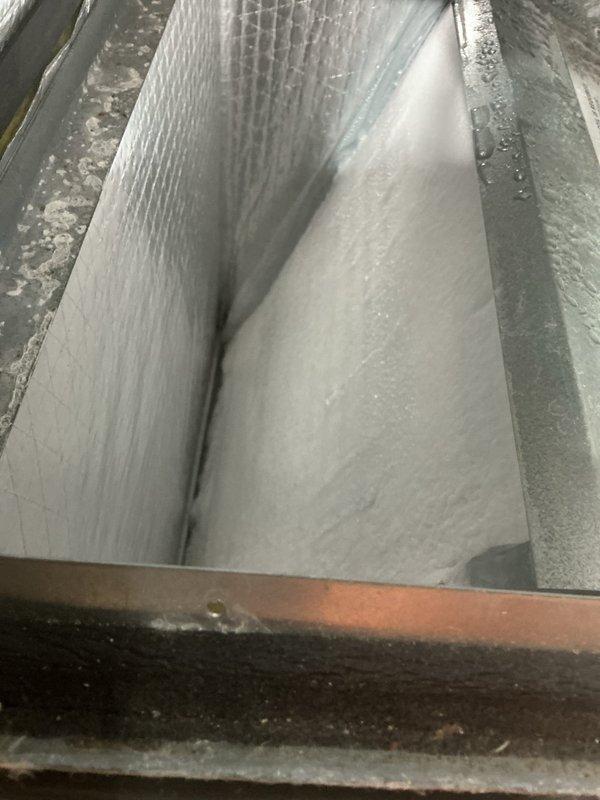 Responded to no-cooling complaint on downstairs 10-year-old A/C unit unable to reach setpoint temperature. Performed system inspection and accessed air handler to evaluate evaporator coil and airflow components. Inspected evaporator coil fins for cleanliness and proper condition, confirmed coil integrity and adequate fin spacing. Verified filter installation and positioning within plenum tracks, documented filter media condition and airflow pathway. Photographed internal components including heat exchanger assembly, blower housing, and filter plenum for service records.