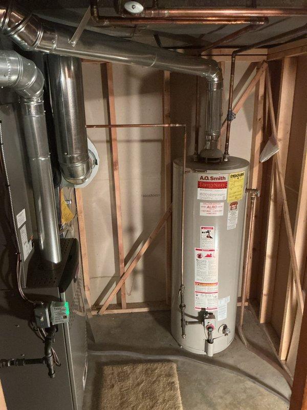 Completed installation of 50-gallon tall gas water heater (A.O. Smith EnergySaver model) under permit #26plu-192205 in basement utility area. Installed new 3/4" pressure reducing valve to regulate incoming water pressure and 1/2" Propress ball valve for main water supply control. Replaced two Level 2 frost-free hose bibs to prevent exterior freeze damage. Installed 5/8" OD x 3/8" OD compression lead-free 1/4-turn angle stop valve (PFXQAC32C) for fixture supply connection. Installed laundry box with integrated hammer arrestor (model 38540 LB4312HA) to eliminate water hammer and provide proper washing machine connections. Connected all copper supply lines to water heater using proper fittings and secured gas line connections per code requirements. Verified all plumbing connections for leaks, tested temperature and pressure relief valve operation, and confirmed proper venting of combustion gases. Unit tested and operational upon completion.