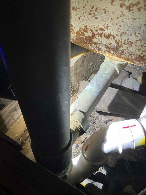 Responded to bathtub/shower drain backup with extremely slow drainage in 1931-era home. Accessed drain system through floor opening and inspected plumbing infrastructure, revealing significant corrosion and deterioration in existing cast iron waste lines. Successfully cleared obstruction and verified proper drainage flow, addressing persistent issue that remained after previous pipe replacement repair.