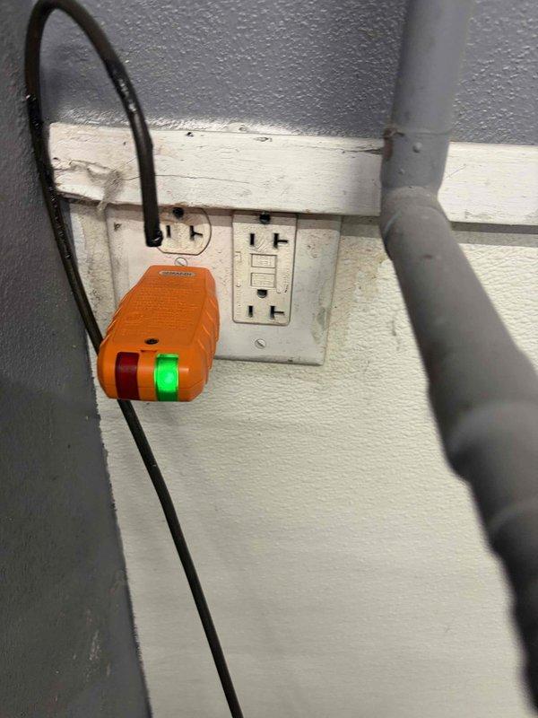 Responded to service call for commercial electrical outlet assessment. Upon arrival, performed comprehensive evaluation of exterior electrical outlets requiring replacement. Inspected dual-outlet configuration including standard duplex receptacle and GFCI outlet mounted on exterior wall with weathered trim board. Conducted electrical testing using portable GFCI circuit tester to verify ground fault protection functionality and circuit integrity. Evaluated electrical meter panel installation containing dual digital utility meters with associated conduit and protective enclosures. Documented existing conditions through photographic evidence showing outlet configuration, protective devices, and meter infrastructure. Provided estimate for outlet replacement work addressing weathering concerns and ensuring code-compliant GFCI protection for exterior receptacles.