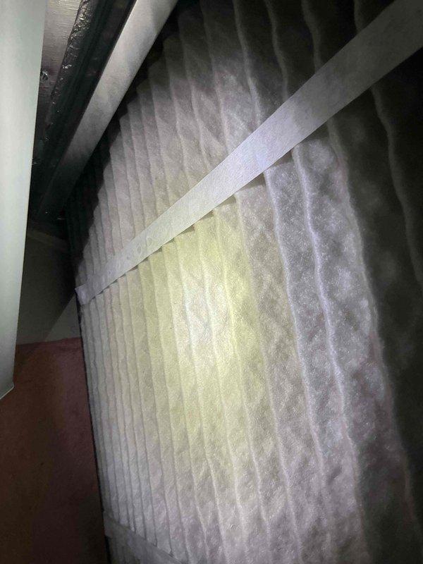 Performed comprehensive tune-up and maintenance on a 2-year-old Lennox air conditioning system operating within normal parameters. Inspected air filter in attic air handler, which showed moderate dust accumulation consistent with normal usage; verified proper installation and secure mounting within filter housing. Confirmed Sensi thermostat functionality with accurate temperature readings at 74°F and system controls responding appropriately in off mode.