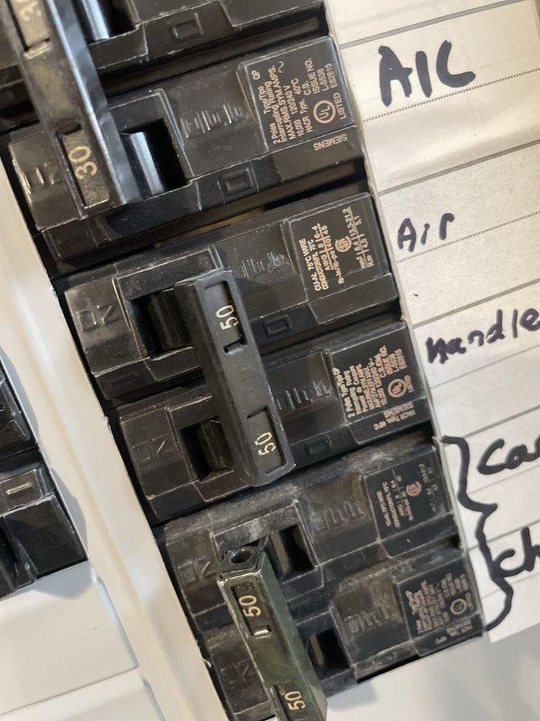 Responded to report of heat kit tripping breaker on basement AC unit. Inspected electrical panel and verified 30-amp breaker serving the air handler was experiencing overload condition. Examined thermostat operation showing cooling mode active with 75°F current temperature and 79°F setpoint. Identified heat kit as source of electrical fault causing breaker trips. Documented panel labeling indicating "Air Handler" circuit and photographed thermostat settings and breaker configuration for reference.