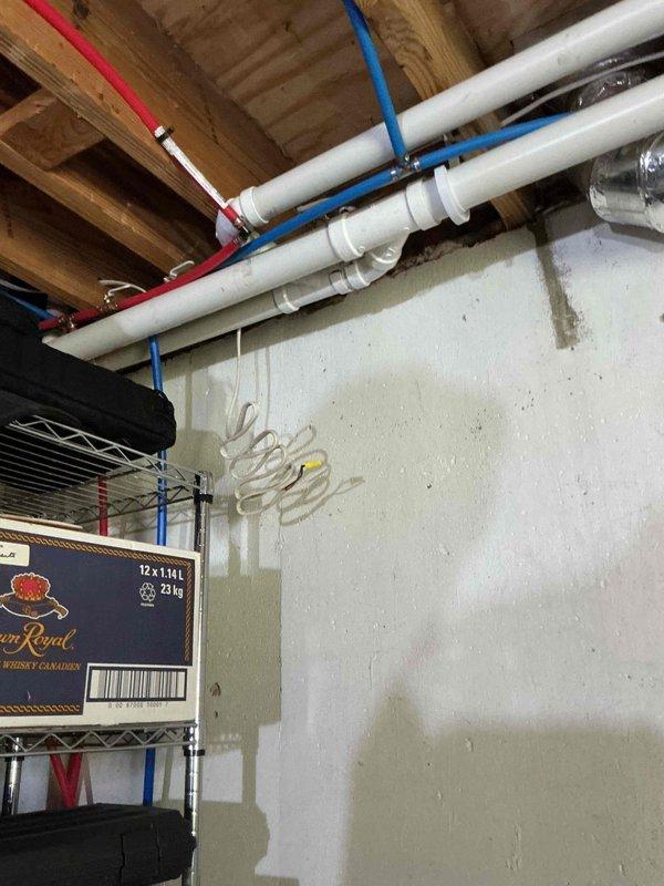 Performed comprehensive camera inspection of residential plumbing system in basement utility area. Documented white PVC drain and vent line configuration, including vertical runs with loop-style routing along interior walls, as well as horizontal piping secured to ceiling joists with proper metal clamps. Inspected blue flexible tubing and additional piping infrastructure for proper installation and condition. All photographed components showed proper installation with no visible defects or immediate concerns noted during visual assessment.