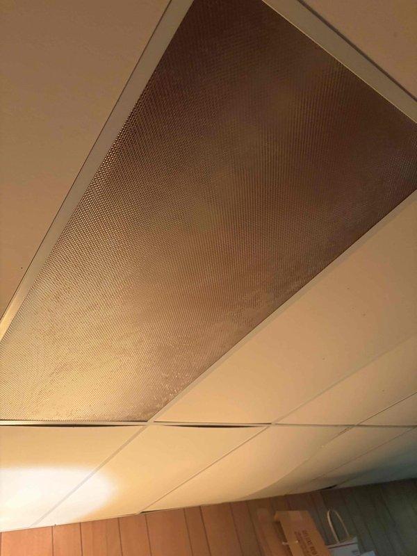 Completed installation of ceiling-mounted light fixture in residential interior space. Fixture features dark circular base with frosted glass cover, successfully wired and tested for proper illumination. All electrical connections secured to code and fixture mounting verified stable.