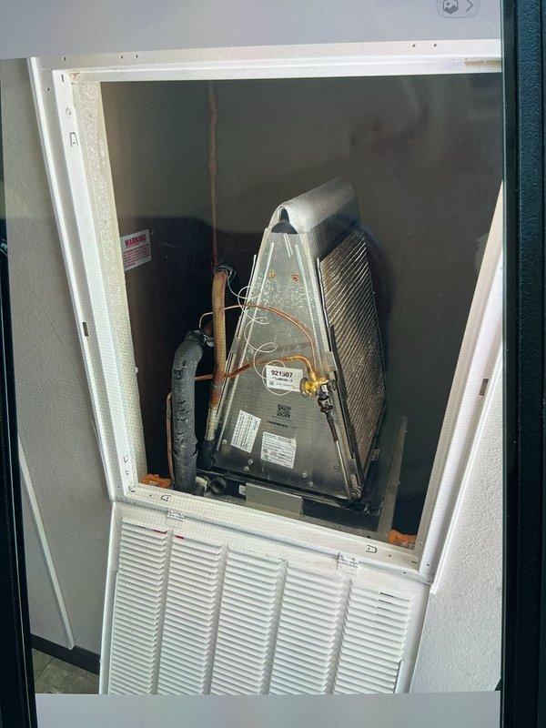 Responded to no cooling complaint on 5-year-old package unit serving 1200-1500 square foot residence. Accessed wall-mounted evaporator compartment and inspected A-frame coil assembly, copper refrigerant lines, and compressor. Connected manifold gauge set to outdoor condenser unit and performed refrigerant pressure diagnostics to evaluate system performance. Verified proper operation of condenser fan and assessed overall system functionality to restore cooling capacity.