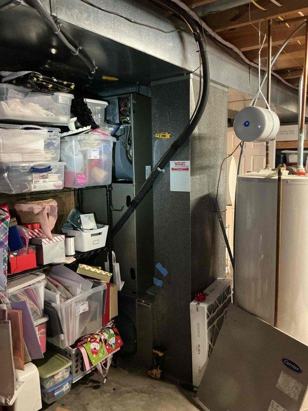 Completed comprehensive tune-up and maintenance service on residential HVAC system consisting of air conditioning unit and furnace located in basement utility area. Inspected Carrier equipment, replaced air filters showing significant dust accumulation, verified proper operation of all components including humidifier system, and confirmed both heating and cooling systems functioning within normal parameters with no deficiencies noted.