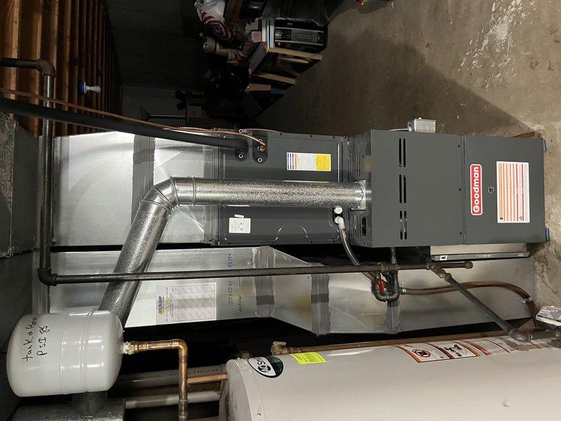 Responded to service call for loud train-like noise coming from outdoor condensing unit during AC operation. Performed diagnostic inspection of residential split system with Goodman air handler. Identified issue with outdoor unit operation and documented system configuration including refrigerant line connections, ductwork assembly, and indoor equipment installation for repair recommendations.