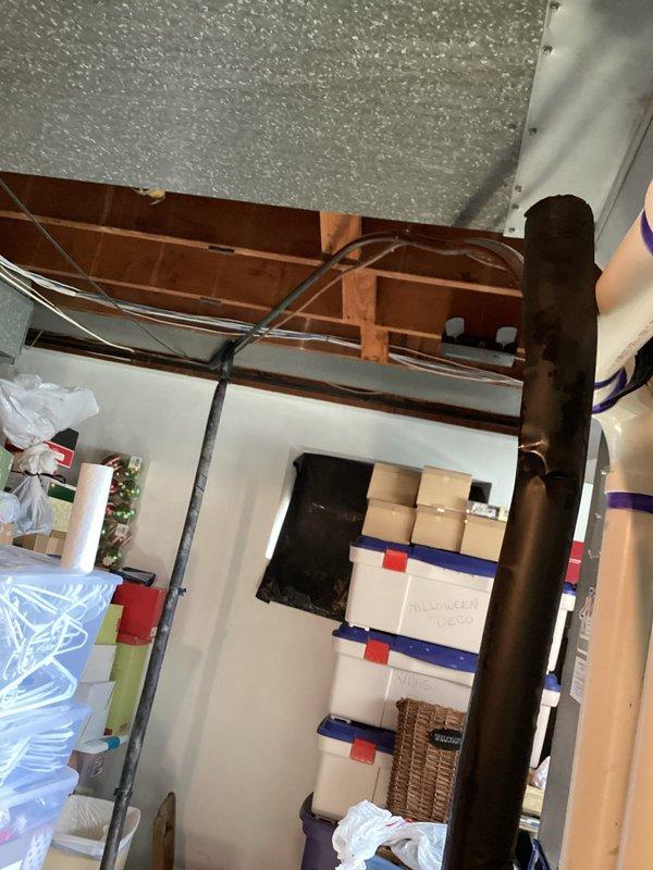 Responded to callback for condensation issue with greasy discharge from air conditioning system. Upon inspection, found improper condensate drain line installation in attic space with excessive tape repairs and compromised drainage causing water to leak onto floor below. Inspected refrigerant lines, condensate routing, and mechanical connections in ceiling cavity. Documented existing conditions showing temporary repairs to drain line that were failing, resulting in moisture accumulation and oily residue discharge. Advised on proper condensate drain line replacement and secure installation to resolve ongoing leakage issue.